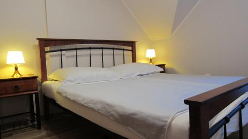 a bedroom with a large bed with two lamps at Appartment Kastelo Victoria in Zalacsány