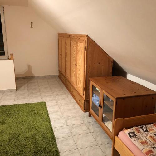 a bedroom with a wooden cabinet and a green rug at Ubytování na Čechách in Děčín