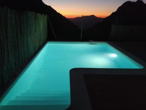 a swimming pool with a sunset in the background at La Atalaya in Benaocaz