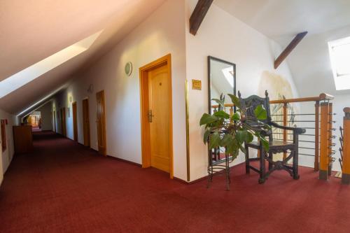 korytarz ze schodami i roślina w środku w obiekcie Hotel Čertousy w Pradze
