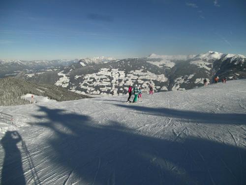 a group of people skiing down a snow covered mountain at Riemenerhof in Fügen