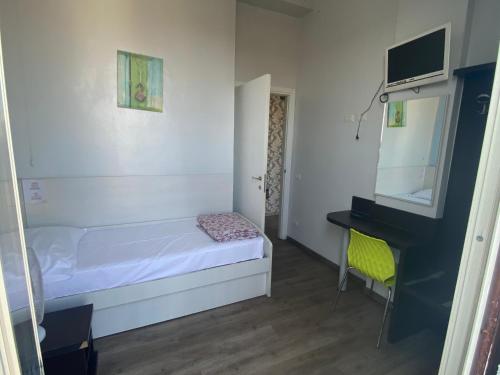 a small bedroom with a bed and a desk at Hotel Kennedy in Milan