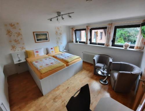 a bedroom with a bed and a desk and a chair at Landhaus Burs in Löningen