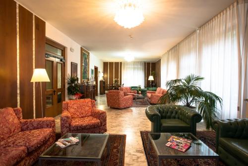 a living room filled with furniture and a large window at Hotel Roma in Pisa