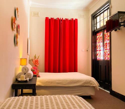 a room with two beds and a red curtain at The Coorow Hotel in Coorow
