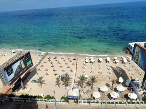 una vista sul tetto di una spiaggia con sedie e ombrelloni di Jewel Mandara Apartments ad Alessandria d'Egitto