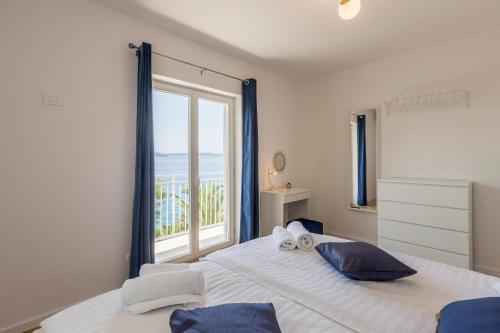 a bedroom with a large bed with a large window at Apartment Shades of Blue in Hvar