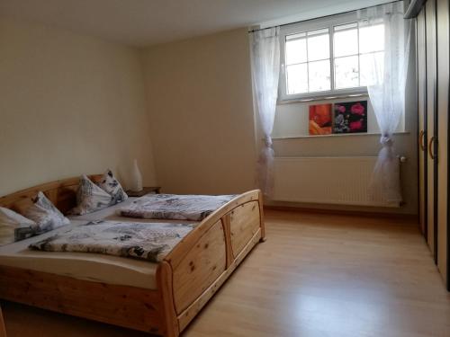 ein Schlafzimmer mit einem Holzbett und einem Fenster in der Unterkunft Landhaus Nobel-Hobel in Kommen