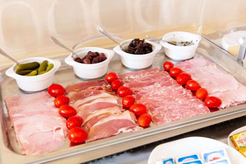 a tray of food with meat and tomatoes and other ingredients at Hôtel Le Maxime - Best Western Signature Collection in Auxerre