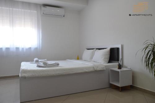 - une chambre blanche avec un lit et une fenêtre dans l'établissement S-Apartmani Cocetova, à Jagodina