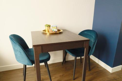 une table en bois avec deux chaises et une plaque de cuisson au-dessus dans l'établissement Rêves Paisibles - Choisy - Saphir, à Choisy-le-Roi