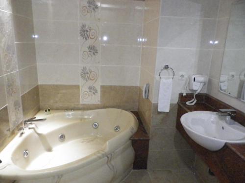a bathroom with a tub and a sink at Sutanraja Hotel & Convention Centre in Soreang