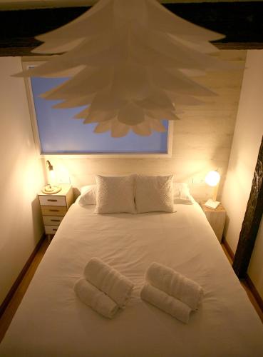 a bedroom with a white bed with two white pillows at El Ático de la Catedral in Logroño