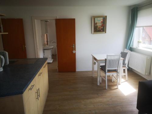 a kitchen and dining room with a table and chairs at Ferienwohnungen und Ferienhaus im Nixenweg in Hohwacht