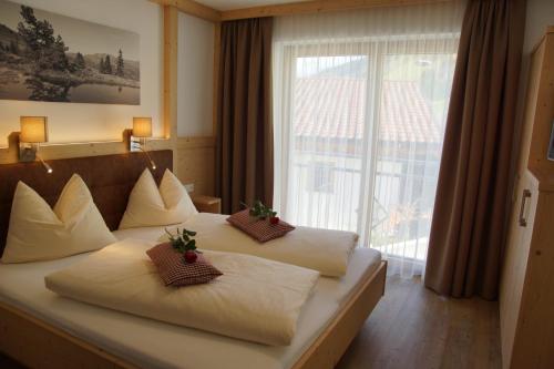 a hotel room with two beds and a large window at Haus Dorfblick in Gerlos