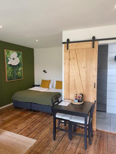 ein Schlafzimmer mit einem Bett, einem Tisch und einem sidx sidx sidx in der Unterkunft Studio appartement 1nul9 in Renesse