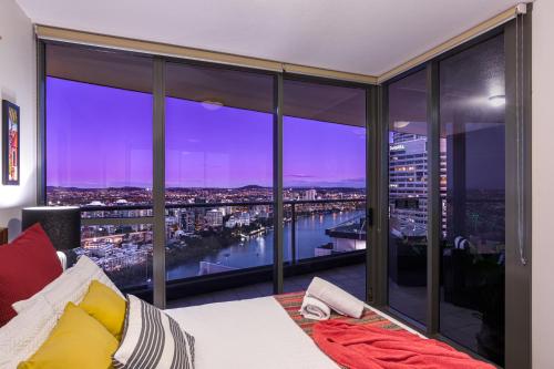 a bedroom with a view of a city skyline at African Sky Retreat - Level 38 CBD Apartment with River Views in Brisbane