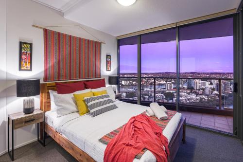 a bedroom with a bed and a large window at African Escape on Level 38 - Balcony with Views in Brisbane