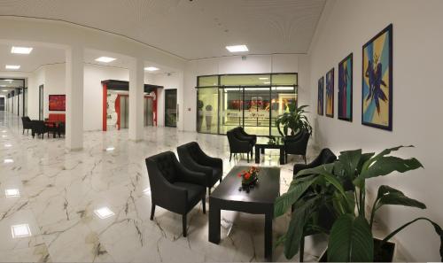 eine Lobby mit Stühlen und einem Tisch in einem Gebäude in der Unterkunft Hotel PreMotel-Premium Motel am Park in Kassel
