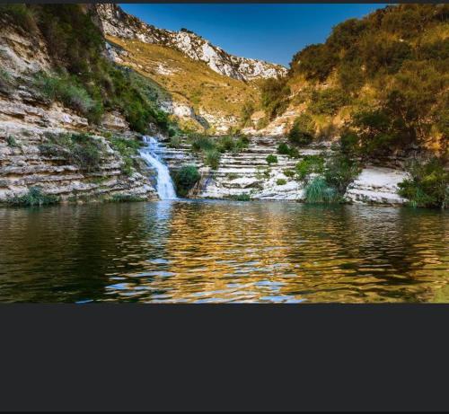 a waterfall on the side of a mountain next to a river at Don Pasqualino in Floridia