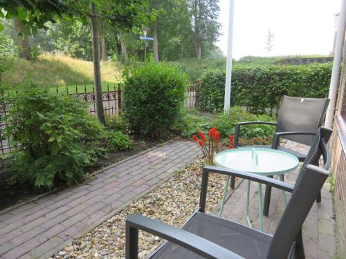 a patio with a table and chairs and flowers at Holiday apartment with free parking Boven Jan Enkhuizen in Enkhuizen
