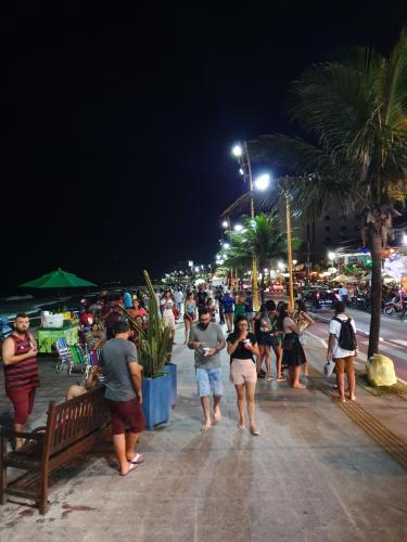 a crowd of people walking down a street at night at Pousada Solar dos Cavaleiros Mendes in Macaé