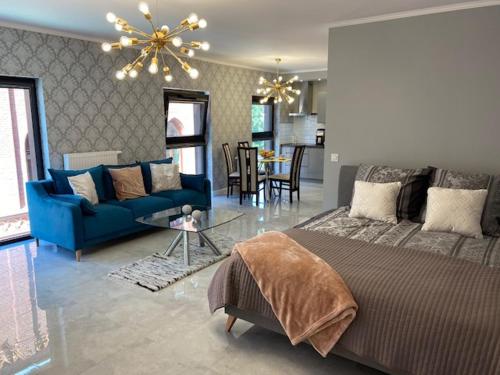 a bedroom with a blue bed and a blue couch at Rezydencja Wintera Great Apartment in Gdańsk