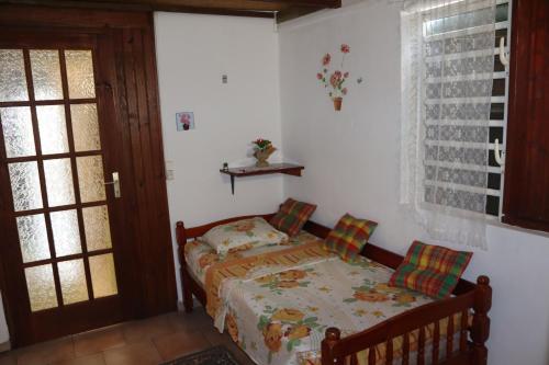 a small bedroom with a bed and a window at Locat dépôt in Bouillante