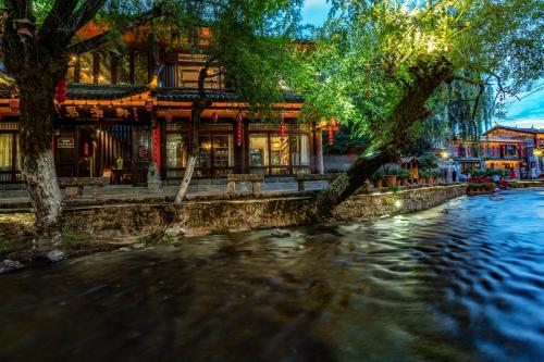 a river in front of a building next to a building at Jun Bo Xuan Boutique Hotel in Lijiang