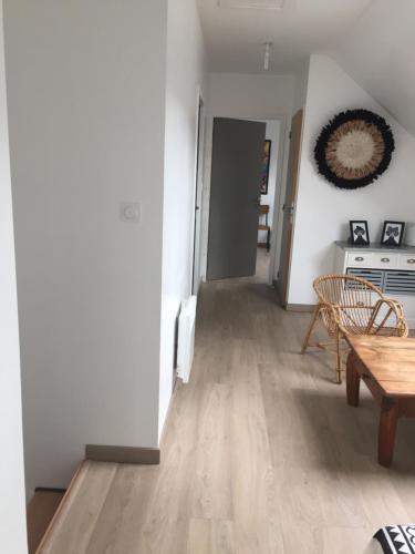 a living room with white walls and a wooden table at La Longère du Salou in Landrévarzec