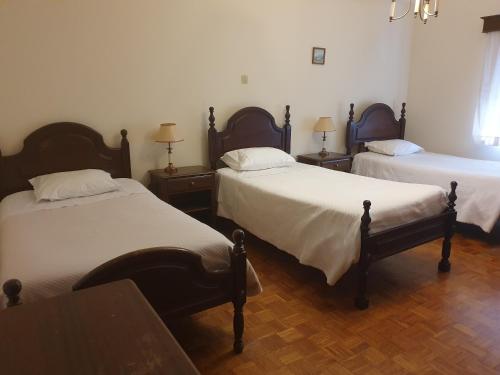 a bedroom with two beds and two tables and a window at Hotel Novo Dia in Meda