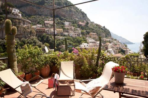 two chairs and a table on a patio with a view of a mountain at Casa Celidea in Positano