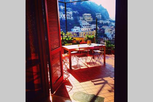a table and chairs on a balcony with a view of a city at Casa Celidea in Positano