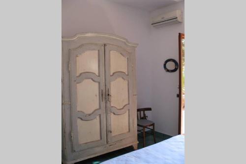 a wooden cabinet in a room next to a bed at Casa Celidea in Positano