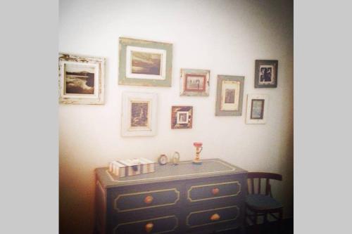 a room with a dresser and pictures on the wall at Casa Celidea in Positano