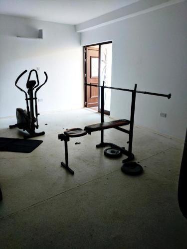 a room with a gym with a bench and weights at 103 ELEGANT 2 bed apartment with free Wifi, AC, pool & gym! in Larnaka