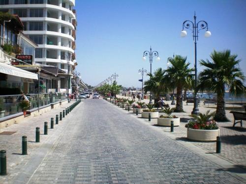 a cobblestone street with palm trees and a building at 103 ELEGANT 2 bed apartment with free Wifi, AC, pool & gym! in Larnaka