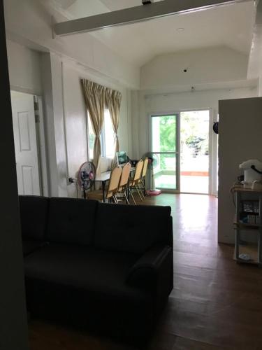 a living room with a couch and a table and chairs at Anna Hostel in Chaiyaphum in Ban Sieo