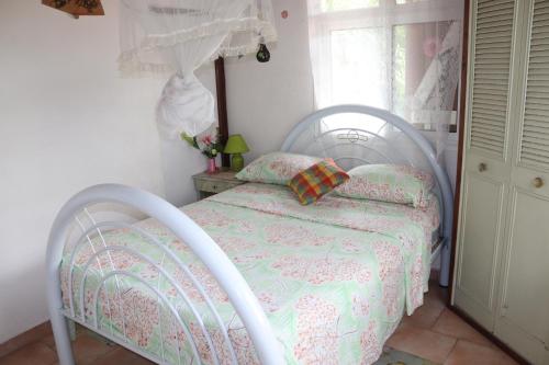 a white bed in a room with a window at Locat dépôt in Bouillante