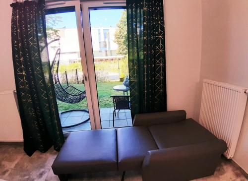 a living room with a couch and a sliding glass door at Na Grobli 20 Apartament z ogródkiem in Wrocław