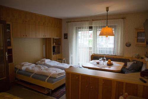 a bedroom with two beds and a table and a window at Apartment Grüner Baum Alpendorf in Sankt Johann im Pongau