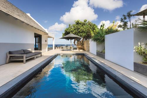 an infinity pool in the backyard of a villa at Oceanfront 72 & Sunny in Kralendijk