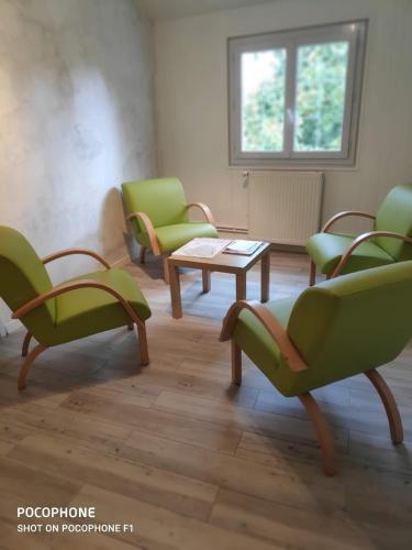 a living room with green chairs and a table at Les ID de Saint Emilion in Saint-Émilion