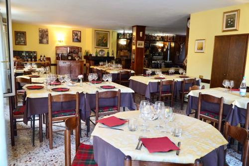 ein Restaurant mit Tischen und Stühlen mit Weingläsern in der Unterkunft Albergo Centrale in Fino del Monte