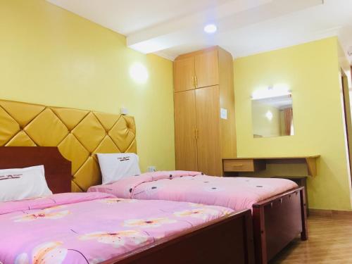 Кровать или кровати в номере Vienna Woods Hotel Nakuru