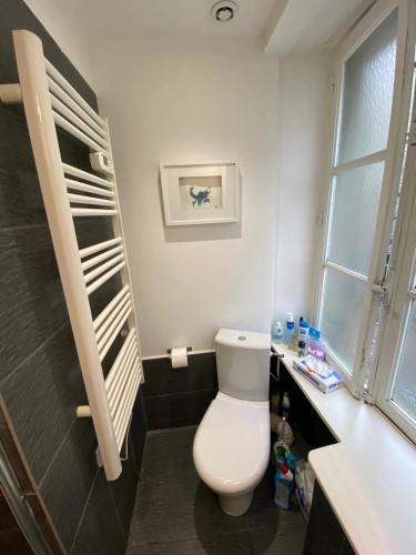 une salle de bain avec des toilettes blanches et un lavabo dans l'établissement La Mettrie, à Saint-Malo