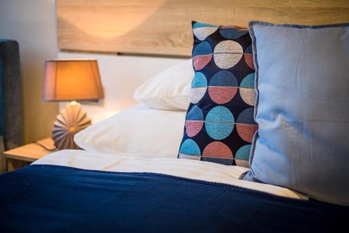 a bed with a pillow and a table with a lamp at Vitis Kúria 7171 Balatonrendes in Balatonrendes