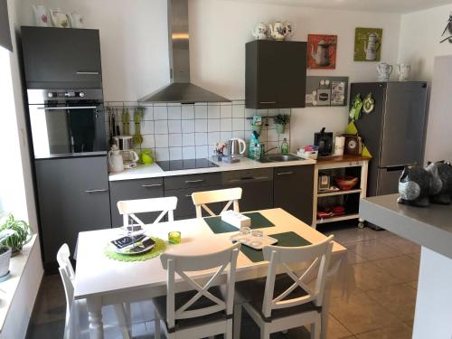 a kitchen with a table and chairs in it at La conciergerie in Hotton