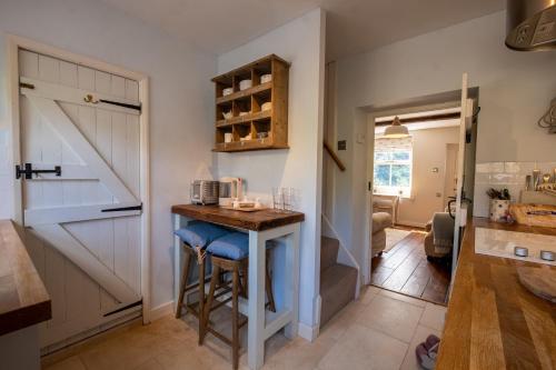 a kitchen with a bar next to a sliding barn door at Sett Cottage in Hayfield