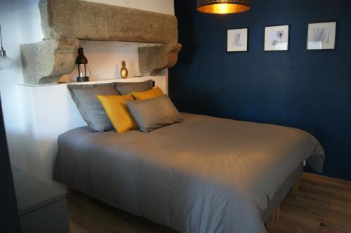 - une chambre avec un lit aux murs bleus et des oreillers jaunes dans l'établissement Le 1777, à Dinan